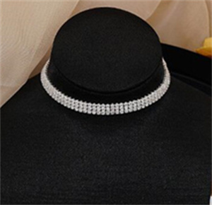 A broader clear-stone choker arrangement on a black neck display