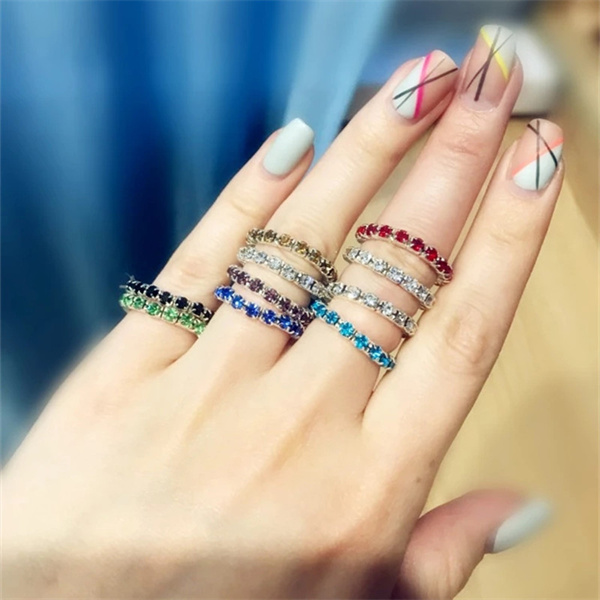 Several colored rhinestone rings shown on a hand